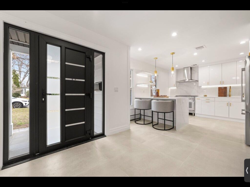 Entryway with black-framed glass doors opening to kitchen