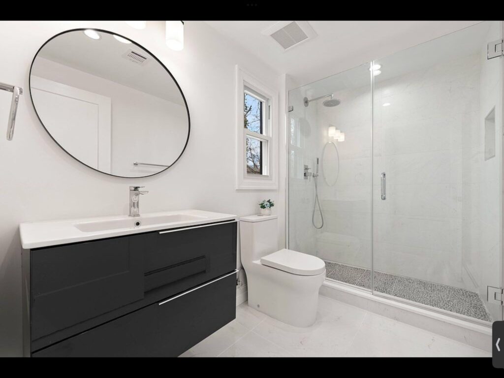 Modern bathroom with black vanity and glass shower